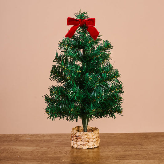 The Darling Effect Green Mini Artificial Christmas Tree, topped with a red velvet bow and set in a woven basket, adds festive charm to any holiday decor.