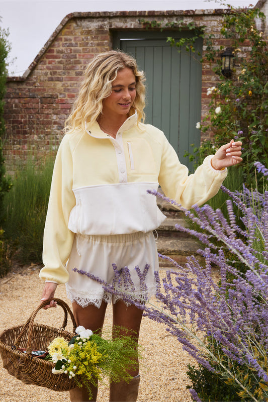Gym+Coffee Snap Polar Fleece Pale Vanilla worn by model in garden Shop Gym+Coffee at Dotique
