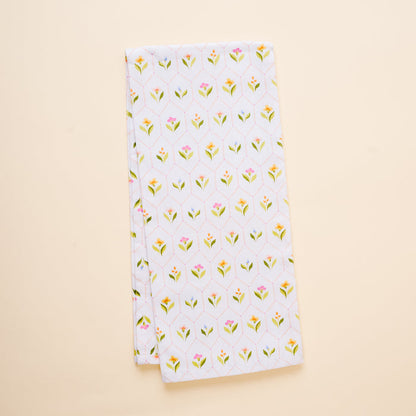 The-darling-effect's Handpicked For You Tea Towel is a neatly folded white cotton towel with small yellow and pink flowers and green leaves, shown on a light beige background.