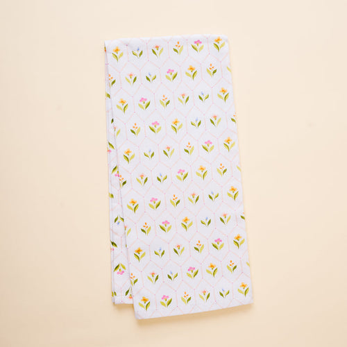 The-darling-effect's Handpicked For You Tea Towel is a neatly folded white cotton towel with small yellow and pink flowers and green leaves, shown on a light beige background.